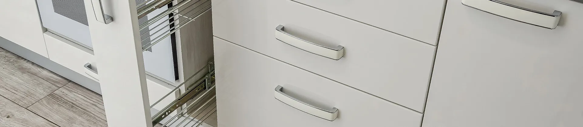 Modern white kitchen cabinets with sleek chrome handles and a pull-out wire storage rack for organized functionality
